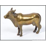A good 19th century Indian brass figurine of a cow having central seam with the back leg stamped `B.