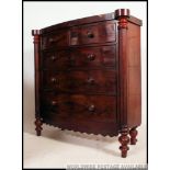 A Victorian bow front Scottish mahogany chest of drawers being raised on turned legs with 2 short