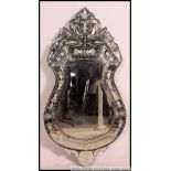 A fabulous 20th century Venetian mirror of shaped form being acid etched decorated with crested top