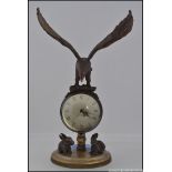 A novelty brass desk ball clock, surmounted with an eagle, the base mounted with two rabbits.