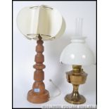 A retro oak mid century table lamp together with a brass and milk glass oil lamp. 23 inch.