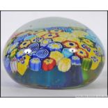 A large glass 20th Century paperweight with a central millefiori cane work panel in mixed colours