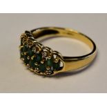 A 9ct gold and emerald ladies ring. The marquise cut emeralds being off pave set ( 12).