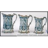 3 Victorian staffordshire graduating jugs in blue/turquoise and white with scrolled handles to each.