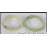 An Apple Green Jade Bracelet together with a bright green jade bangle of similar form