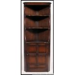 A large Ercol colonial corner cabinet having open shelving over cabinet to the base.