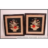 A pair of framed and glazed hand embroidered still life panels set to black fabric backgrounds.