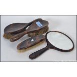 An early 20th century Tortoiseshell 4 piece ladies vanity set to include 3 clothes brushes and a