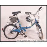 A vintage 20th century folding bicycle together with helmet and dynamo