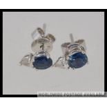 A pair of 18ct white gold diamond and sapphire earrings / studs with beautiful round cut claw