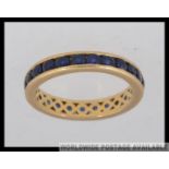 An 18ct gold and sapphire eternity ring with approx 20+ sapphires. Total weight 3.6g / Size L.