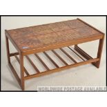 A late 20th Century rectangular teak coffee table with inset fat lava style tiled top,