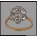 An 18ct gold and diamond ring having 7 20pt diamonds in a daisy setting. Marked 18ct. Weigth 3.2g.