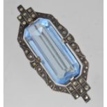 A 1930s Art Deco silver brooch with central blue glass surrounded by marcasite in a geometric