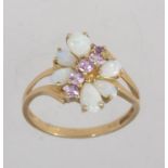 A hallmarked Birmingham 9ct gold ring with opals and pink stones in a butterfly setting with split