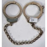 LEG IRONS: A pair of 20th century police style leg irons / cuffs.