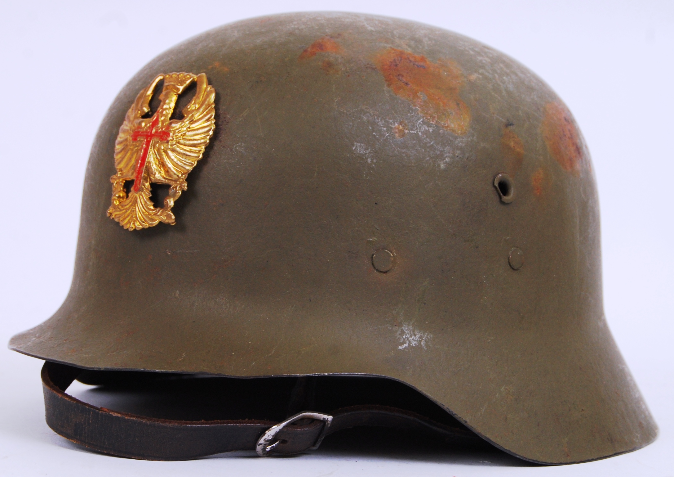 A SPANISH CIVIL WAR (M-42) STEEL HELMET bearing a Civil War brass helmet badge to front,