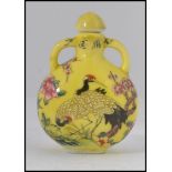 A Chinese enamel painted perfume bottle - moon flask having yellow ground and decorated with