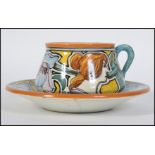 A stunning French faience Art Nouveau cup and saucer having elaborate hand painted decoration of a