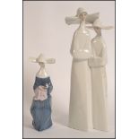 A Lladro porcelain figure group modeled as two Nun's in habits 33cm tall,