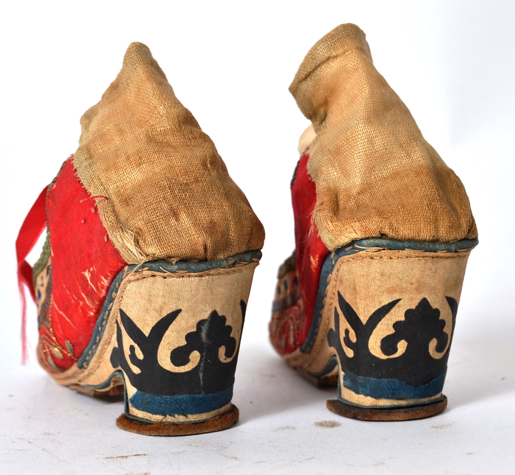 A pair of Chinese red silk and embroidered shoes with laces being handstitched, - Image 3 of 4