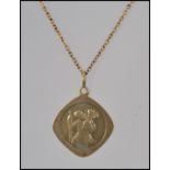 A 9ct gold St Christopher pendant on a rolled gold chain. Pendant weight 1.8g.