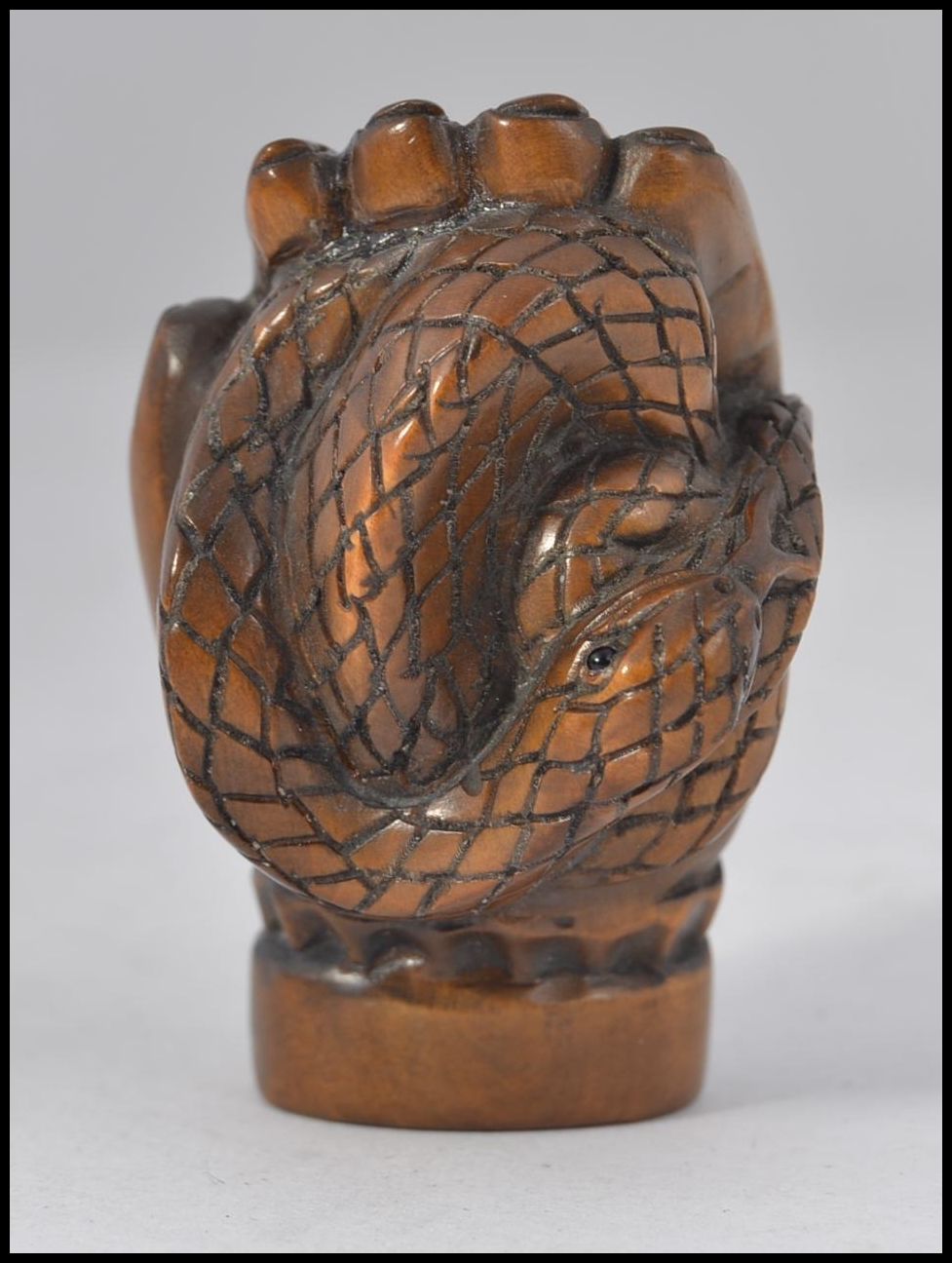 A carved fruitwood Chinese / Japanese netsuke in the form of a hand bearing signature to the base