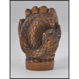 A carved fruitwood Chinese / Japanese netsuke in the form of a hand bearing signature to the base
