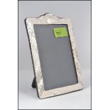 A contemporary silver picture / photo frame with reeded and oak leaf decoration having an easel