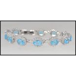 A beautiful silver white metal blue topaz daisy style ladies bracelet,