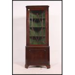 A Georgian mahogany corner cabinet having astragal glazed door cabinet over cupboard beneath.