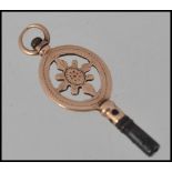 An unmarked gold fob watch winding key tests 14ct gold with pierced decoration. Measures 3cms.