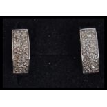 A pair of 9ct white gold and diamond hoop earrings. Weight 3.