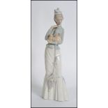 A Lladro china figure modelled as a Young Lady of Fashion holding a Pekingese Dog ( 4893 ) stamped