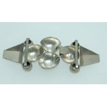 A collection of 1930s Art Deco white metal cloak cape clip clasps to include one with geometric