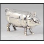A sterling silver vesta case in the form of a pig with hinged head and striker to the base.