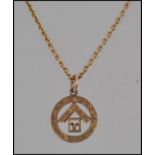 A hallmarked 9ct gold Masonic pendant strung on a 15ct gold chain with clip barrel clasp marked