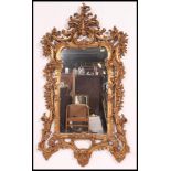 A large 20th century rococo wall mirror having detailed gilt frame with crested top having inset