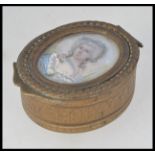 A 19th century Georgian brass oval pill box with lined interior having inset ivory / bone portrait