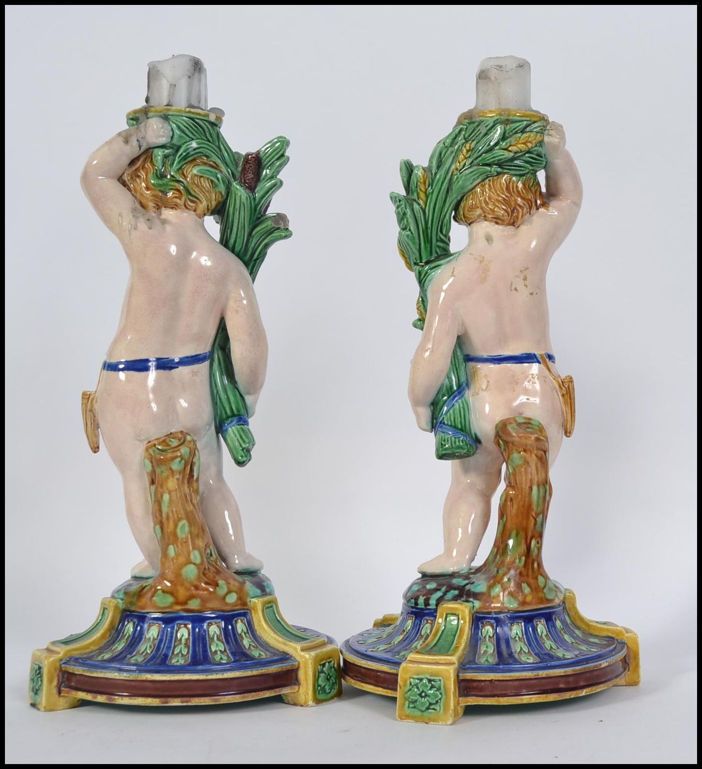 A pair of Minton Majolica figural candlesticks modelled as cherubs raised on naturalistic socle - Image 2 of 5