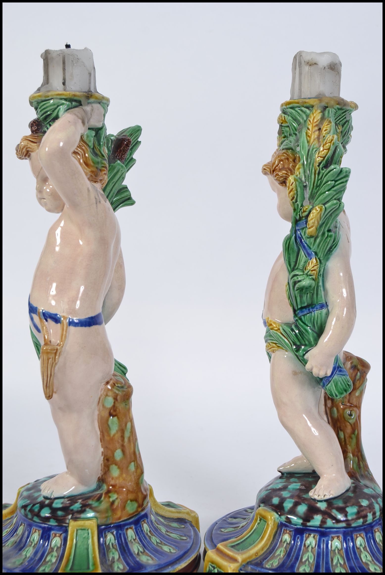 A pair of Minton Majolica figural candlesticks modelled as cherubs raised on naturalistic socle - Image 4 of 5
