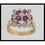 A 9ct gold ruby and diamond ladies dress ring, with four stones set to centre possibly rubies,