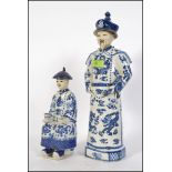 A large Chinese blue and white figurine of a scholar together with a smaller blue and white