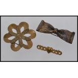 Three early 1920s gold tone brooches all with c clasp one in the form of a flower ,