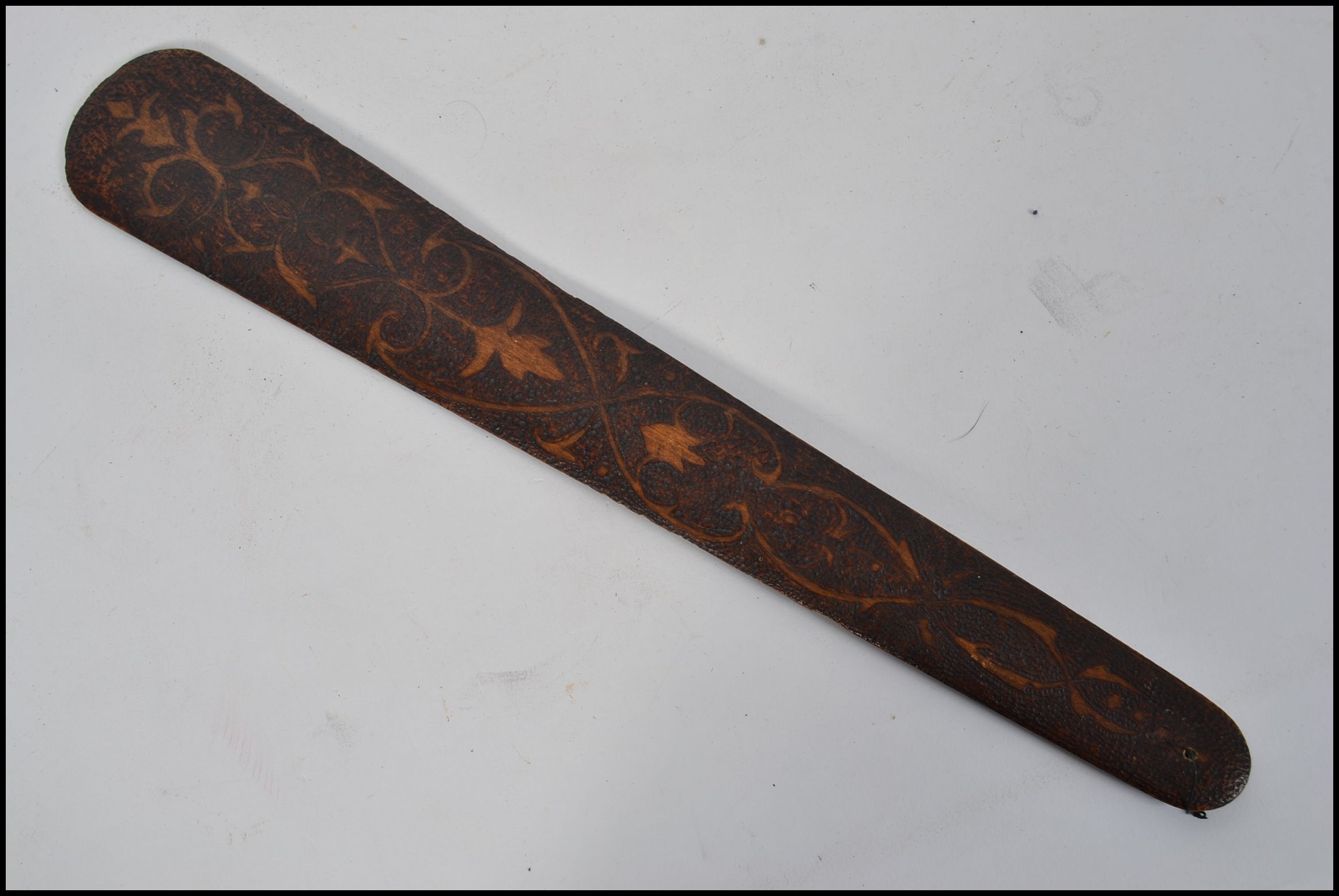 A Victorian poker work page turner / paper knife of tapering form being decorated on both sides
