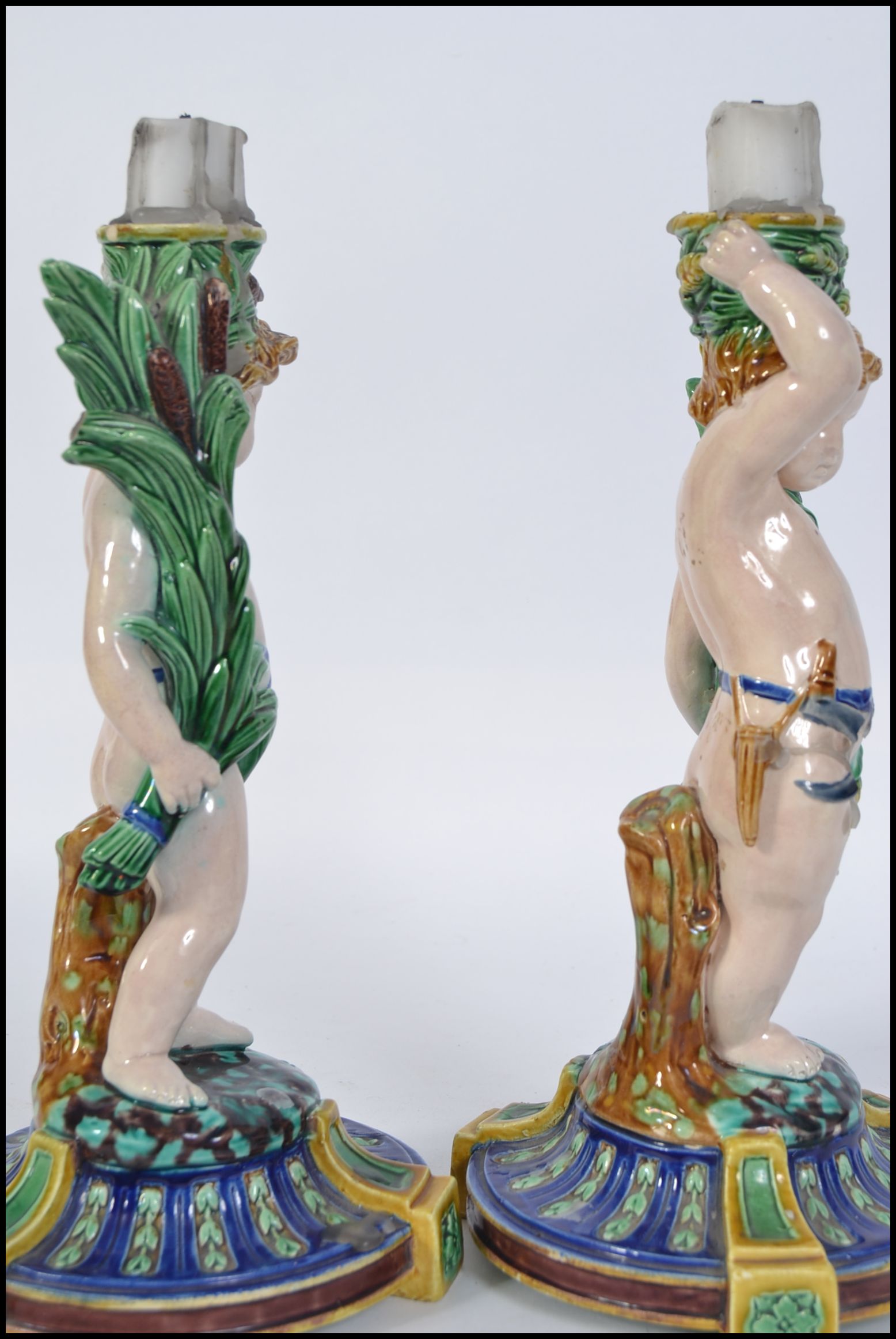 A pair of Minton Majolica figural candlesticks modelled as cherubs raised on naturalistic socle - Image 5 of 5