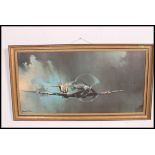 A large framed print of a spitfire in clouded sky being signed to the corner by Barrie Clark 100x50