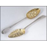 A pair of silver hallmarked berry spoons, chased handles with berry and fern bowls in relief.