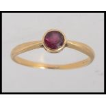 A 9ct yellow metal Art Deco style gold ring (tested to 9ct ) set with a central garnet stone in a