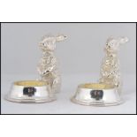 A wonderful pair of silver plated table salts in the form of seated rabbits with salt bowls to the